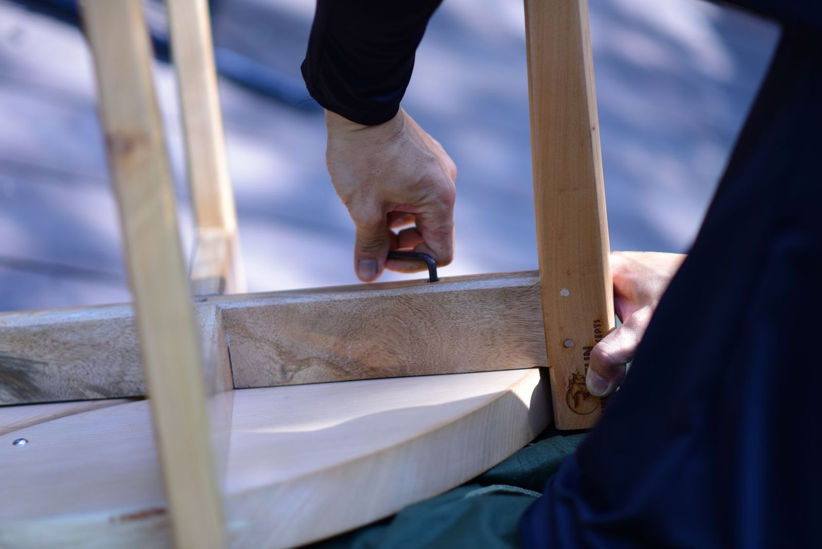 Hände montieren ein Holzmöbel mit dem Inbusschlüssel