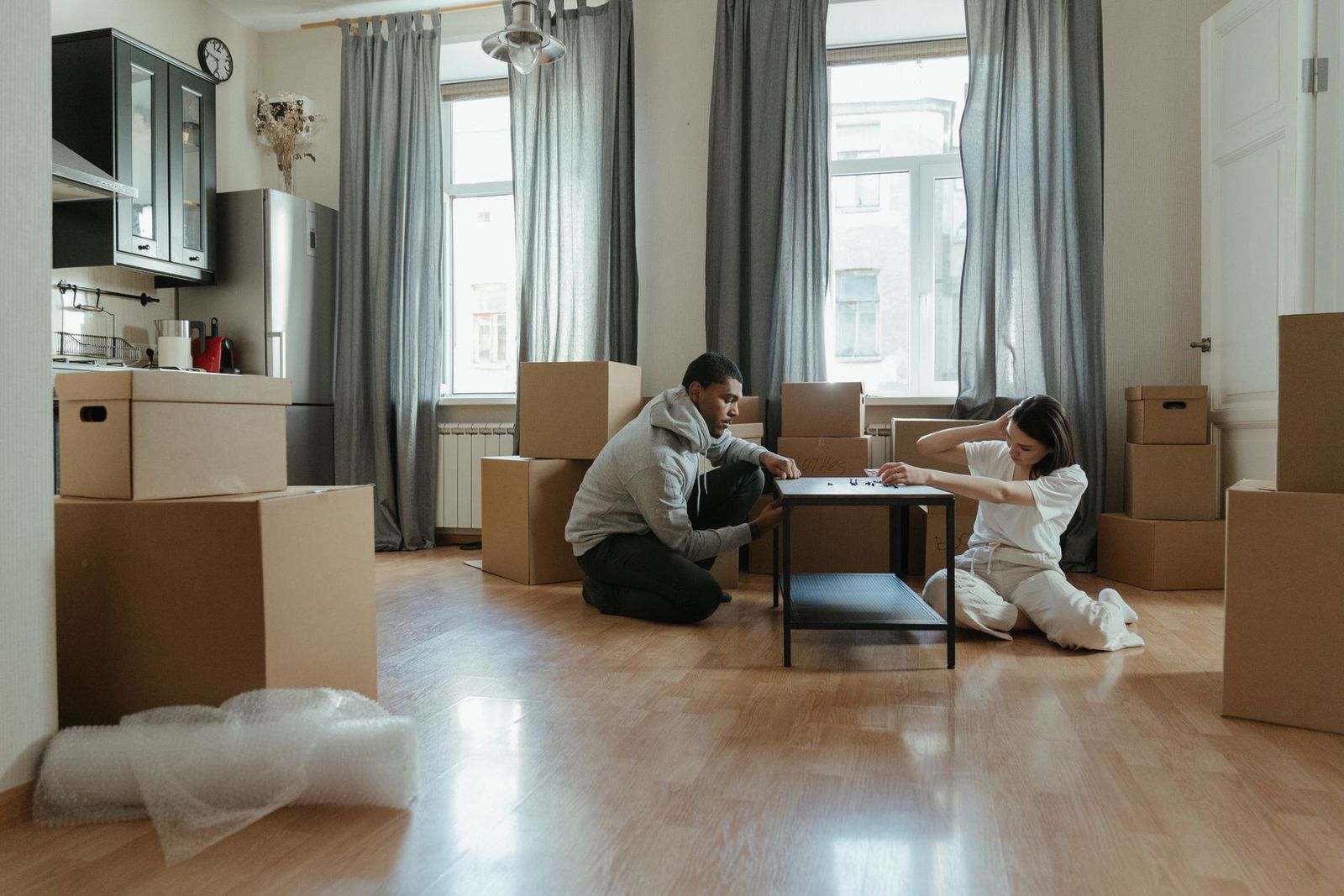 Paar montiert Möbel in der neuen Wohnung, Kartons ringsum